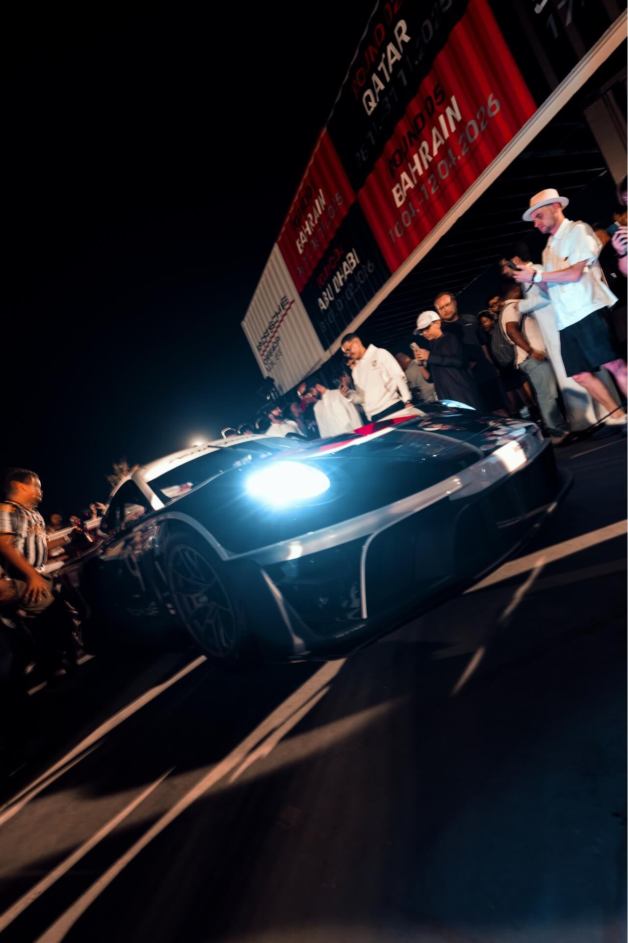 Racing Porsche GT3RS in the night as seen surrounded by people at Icons of Porsche festival