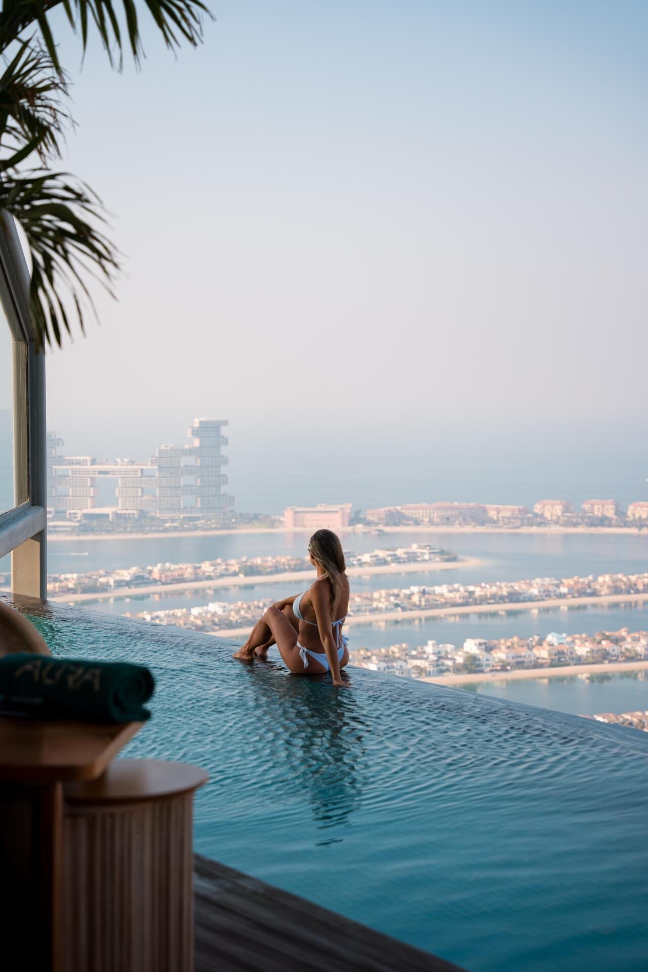 Girl laying on side of swimming pool at Aura with Atlantis the Royal view