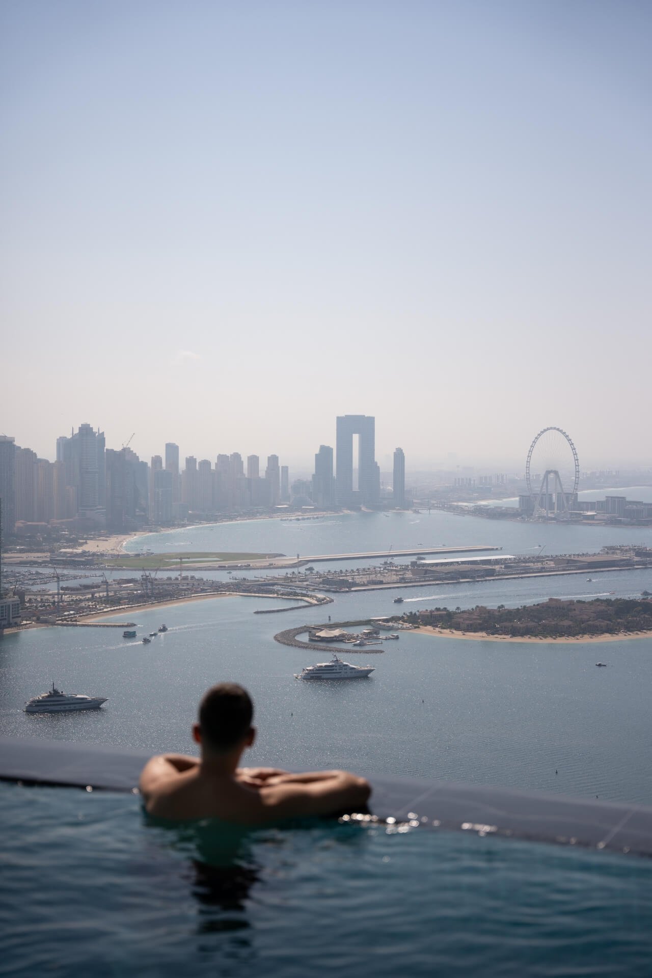 Man inside swimming pool at Aura admiring JBR