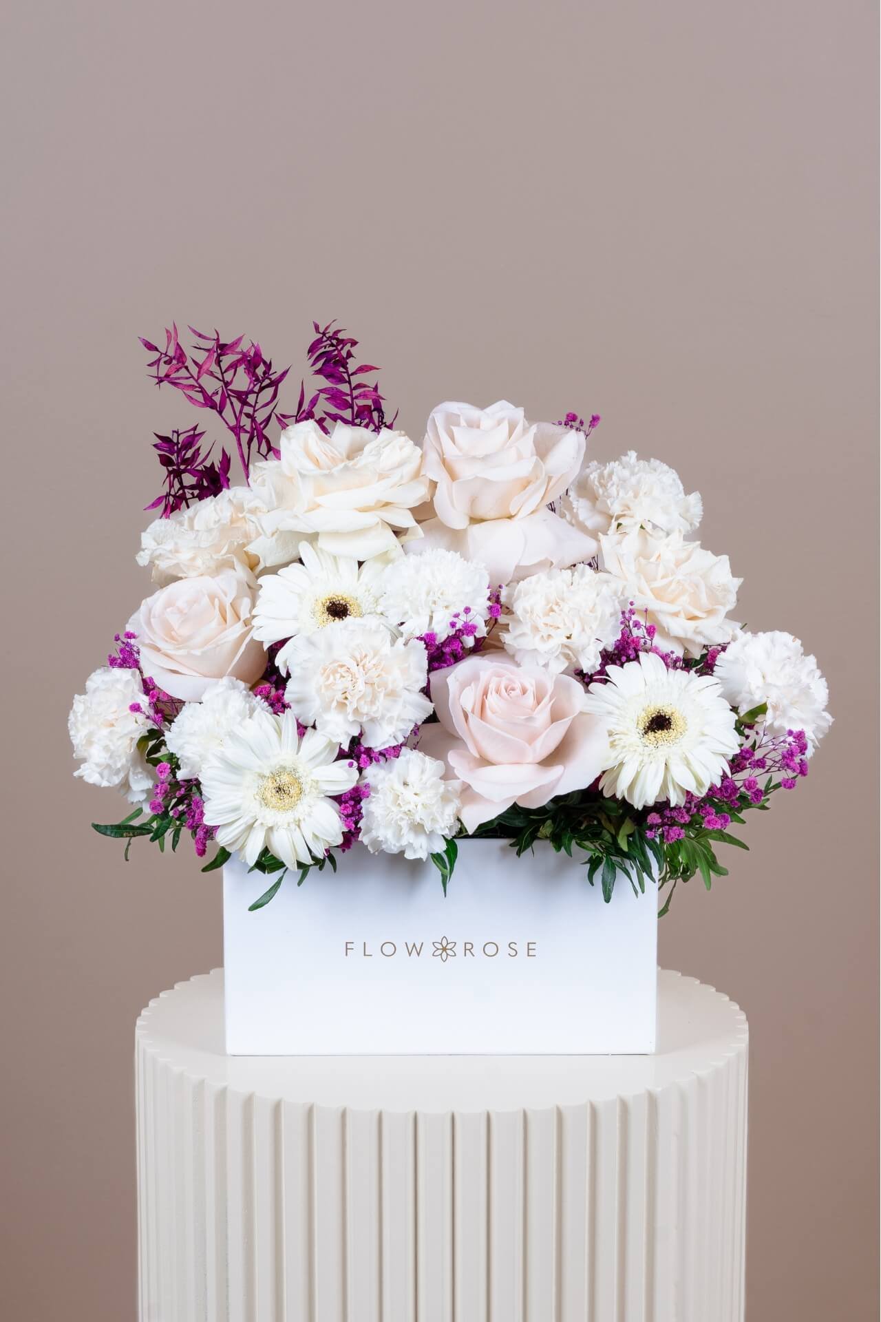 Arrangement of white and purple flowers in a white Flowrose box