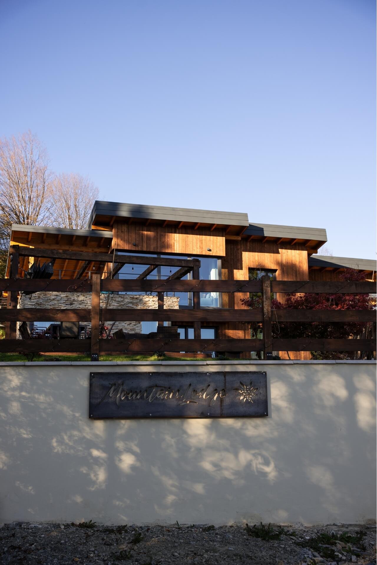 Wide shot of a mountain villa from outside the garden