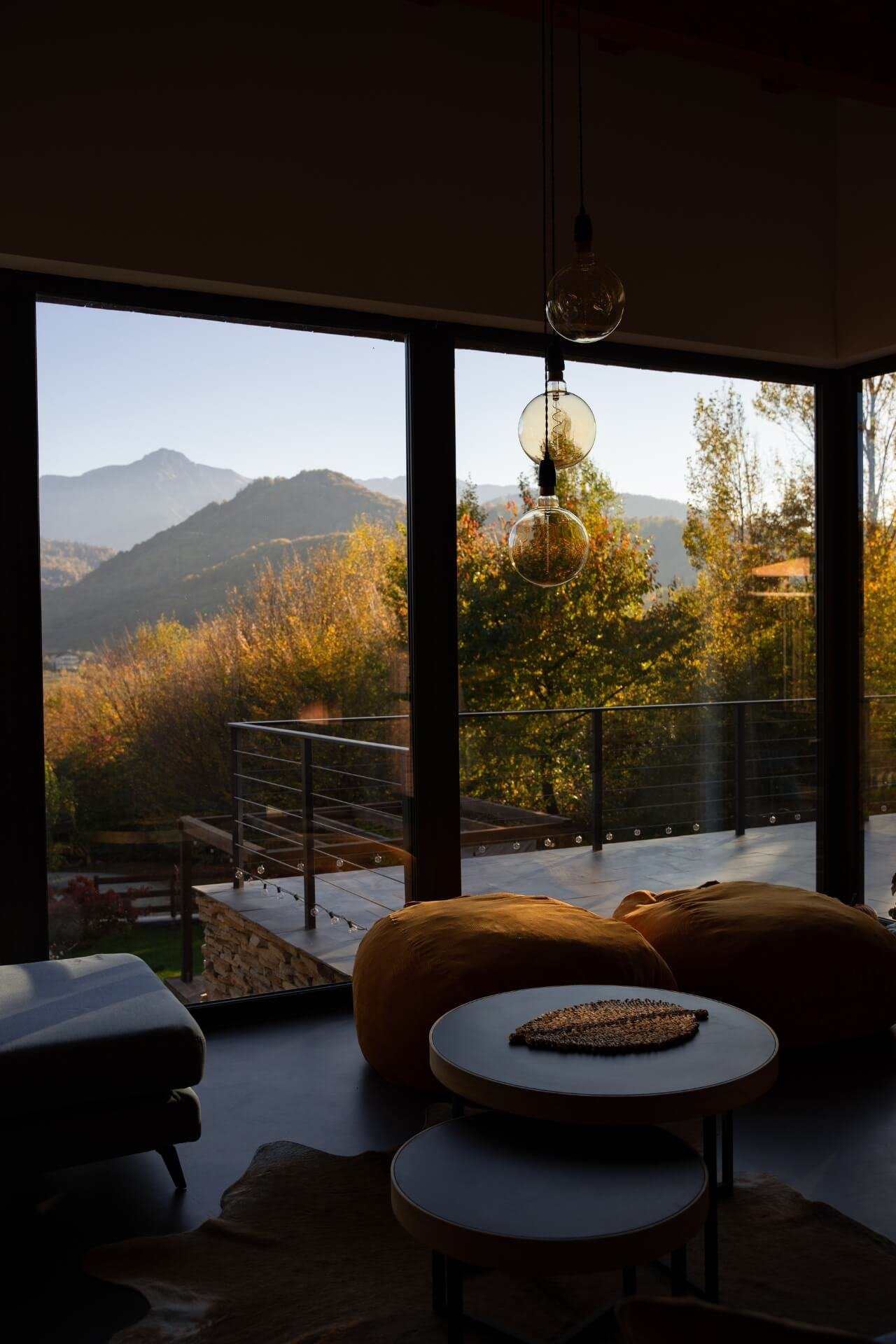 Cozy mountain villa interior with big window and mountains view in autumn