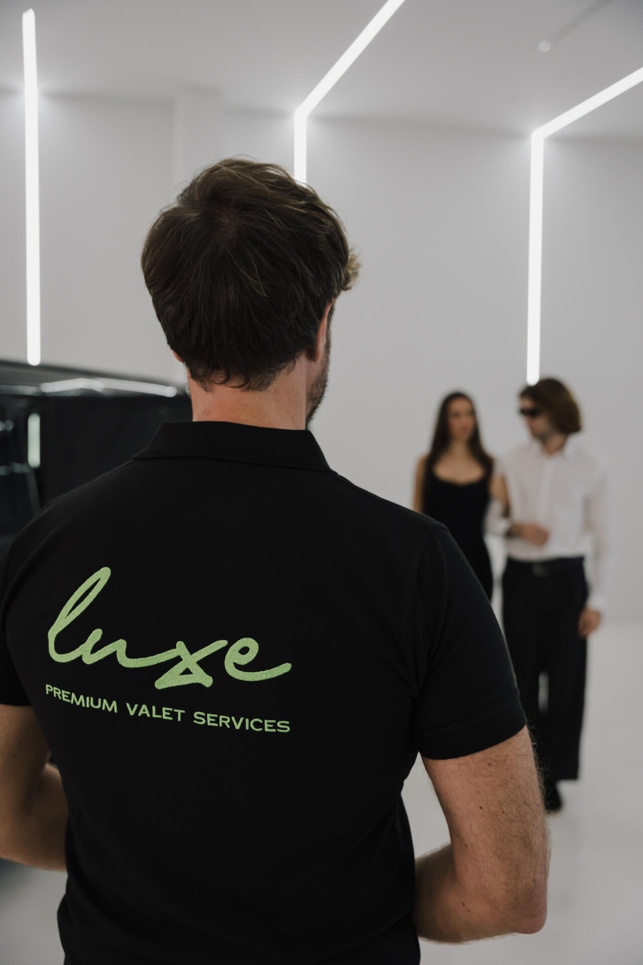 Back of valet with Luxe valet logo in the back and client couple seen in background